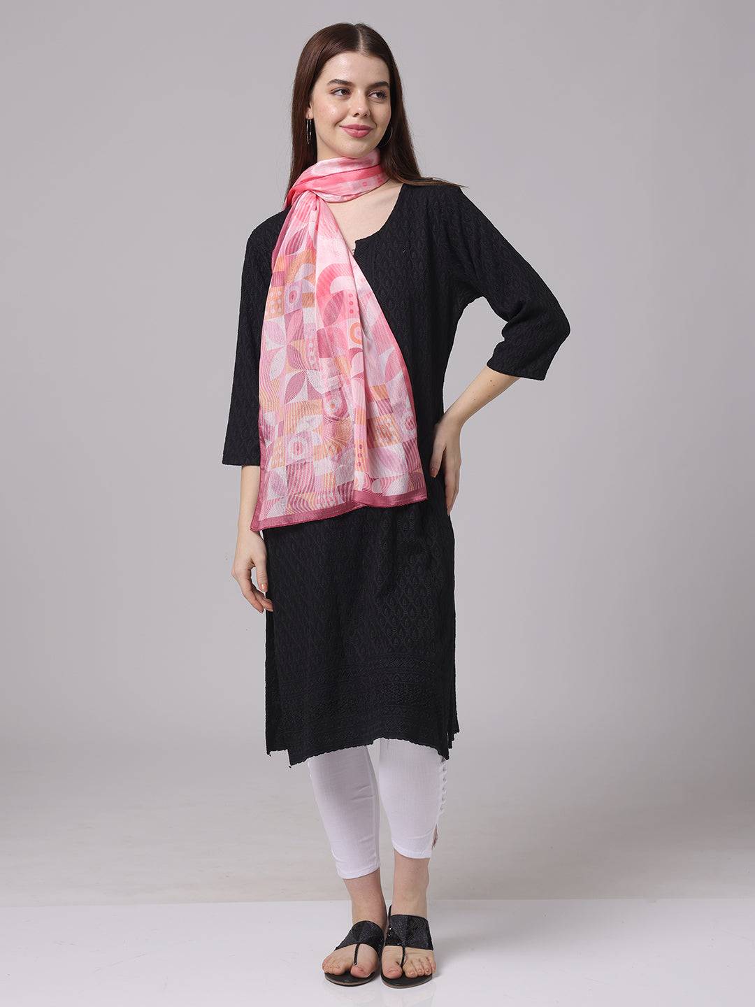 Model wearing pink geometric scarf with black outfit.