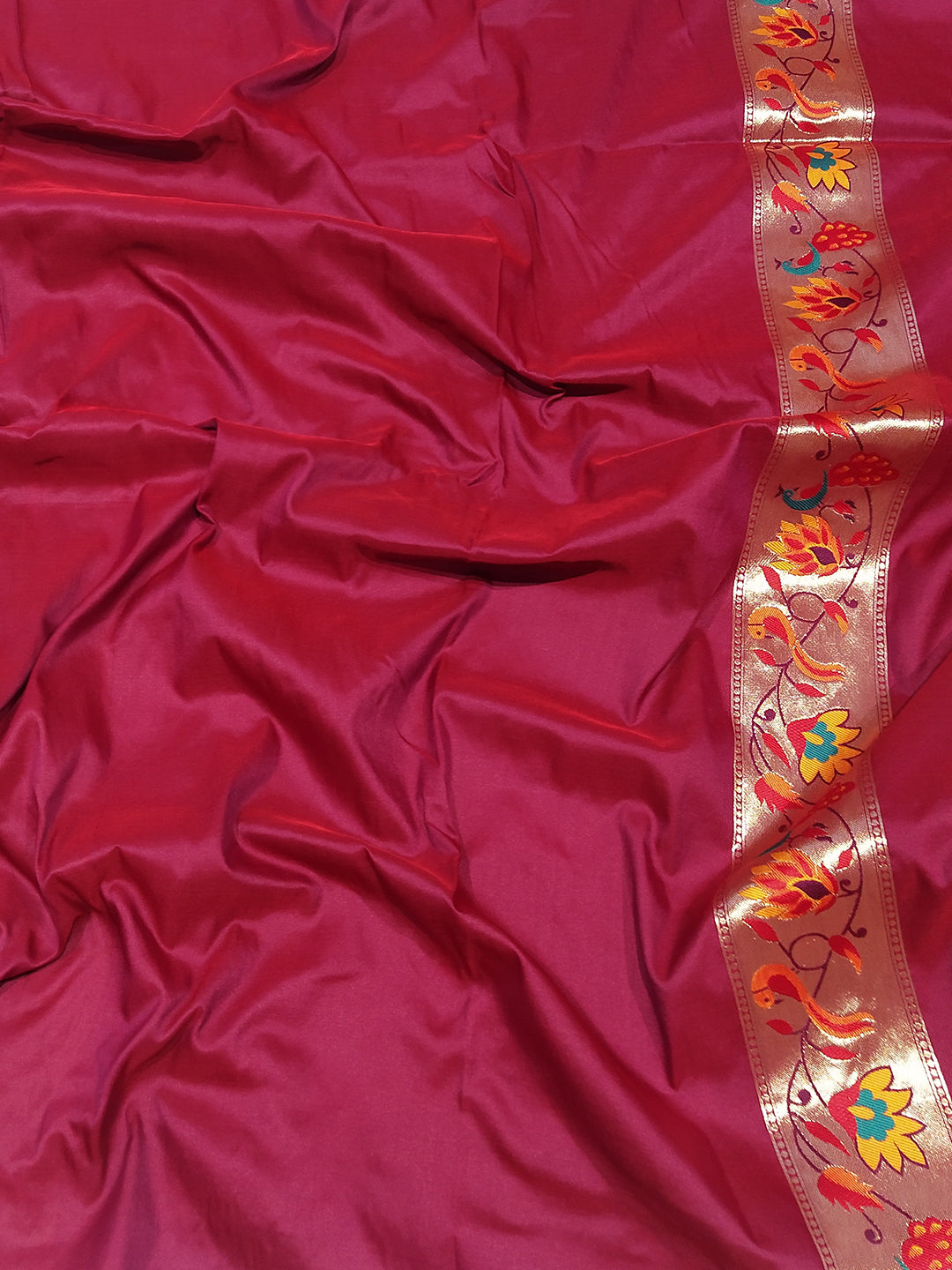 Wine silk blend Paithani saree fabric with floral zari border.