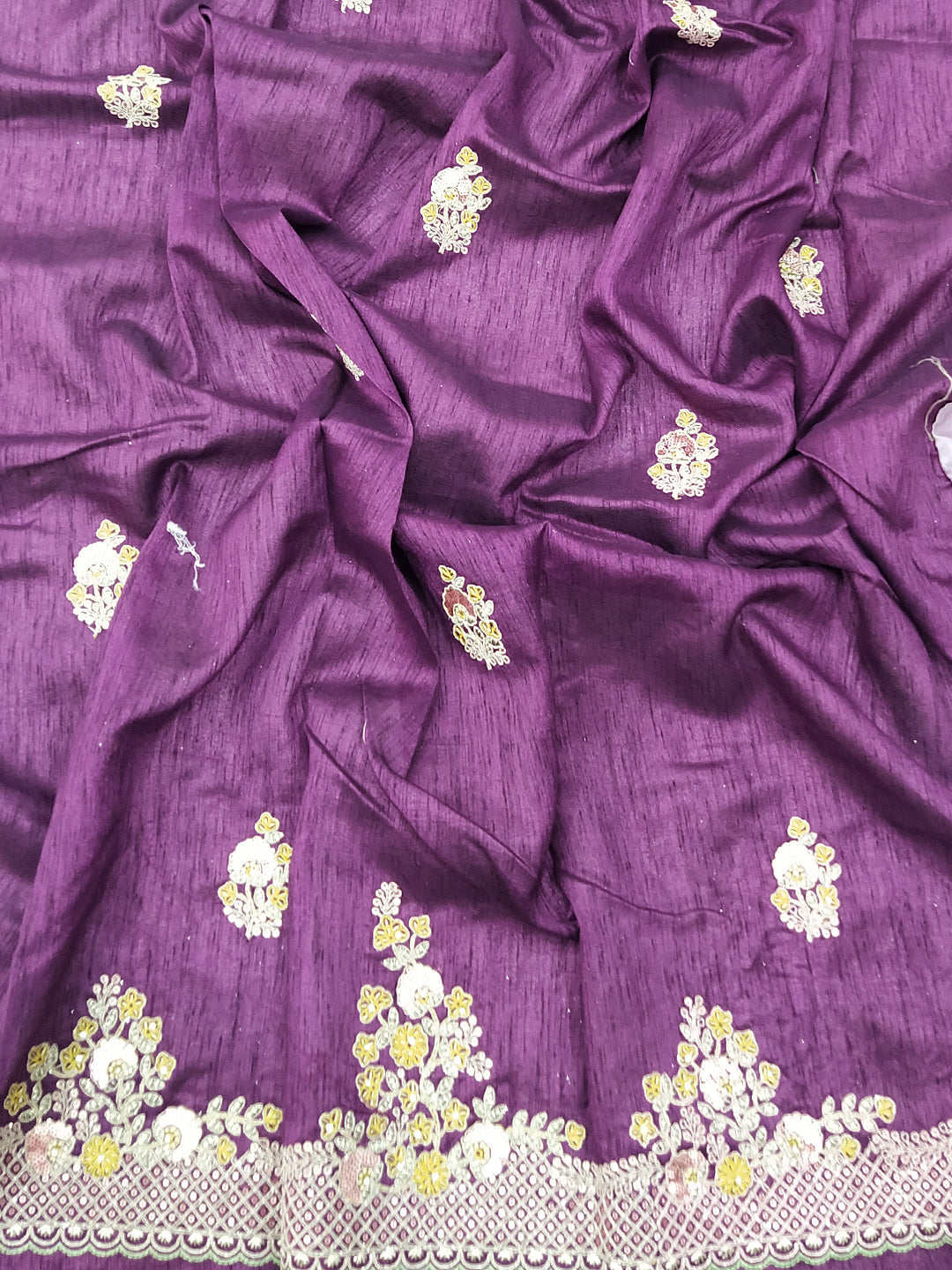 Close-up of silk saree fabric with floral embroidery