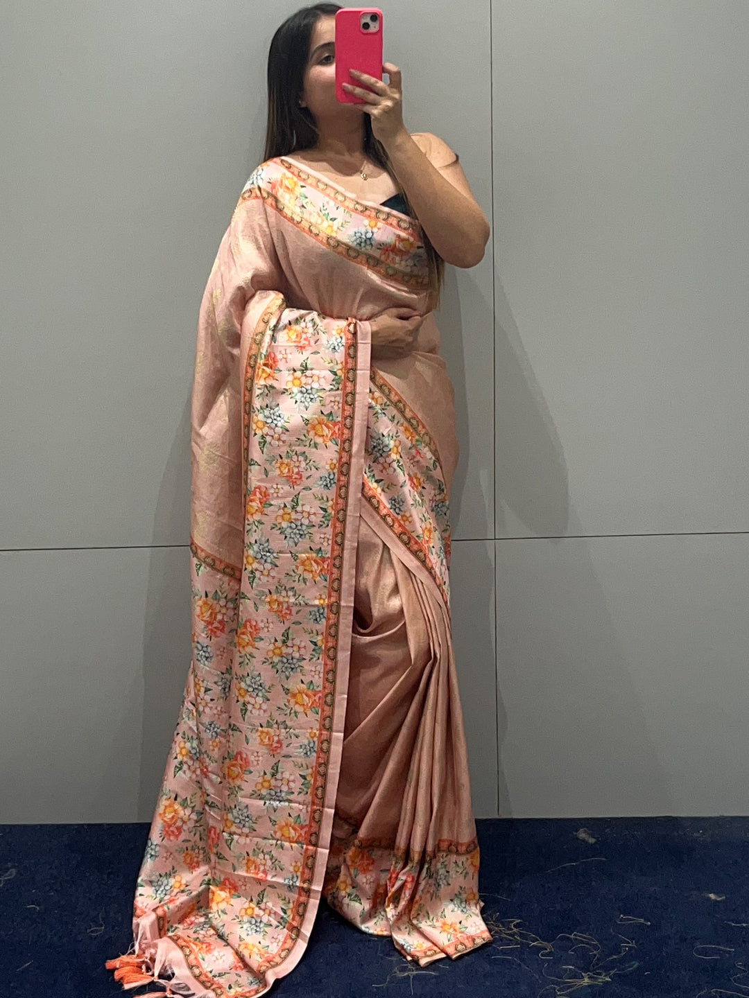 Woman taking a mirror selfie in a Kanjivaram saree with floral design.