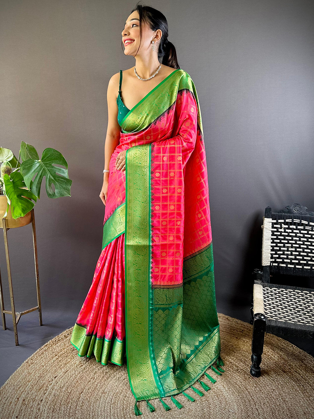 Woman posing in blush pink Banarasi saree with intricate green border