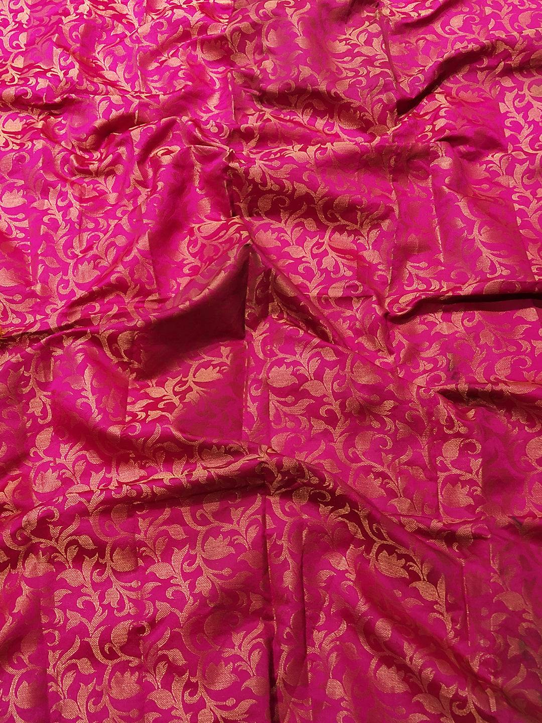 Close-up of vibrant pink Kanjivaram silk fabric with zari