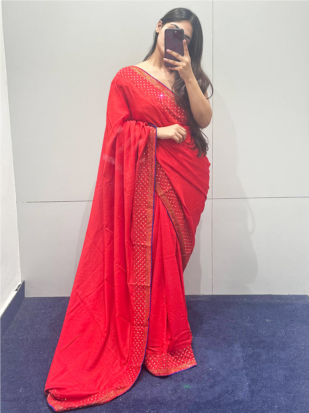 Woman wearing red Vichitra silk saree with Swarovski stones