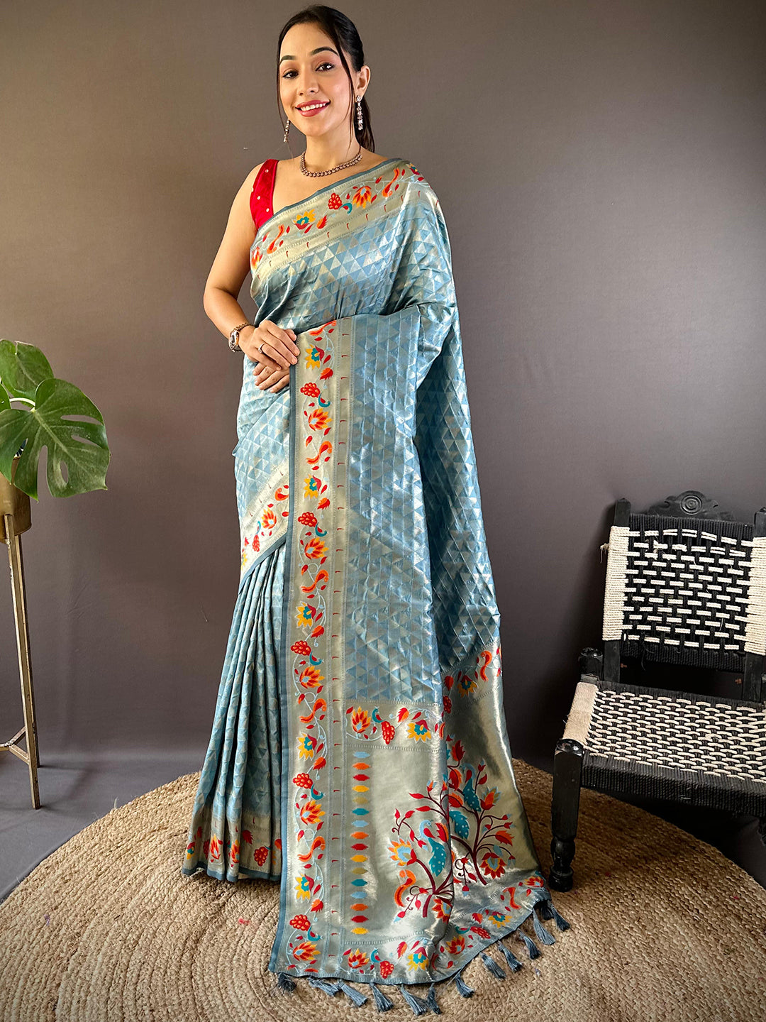 Model wearing light blue Paithani saree with floral zari design.