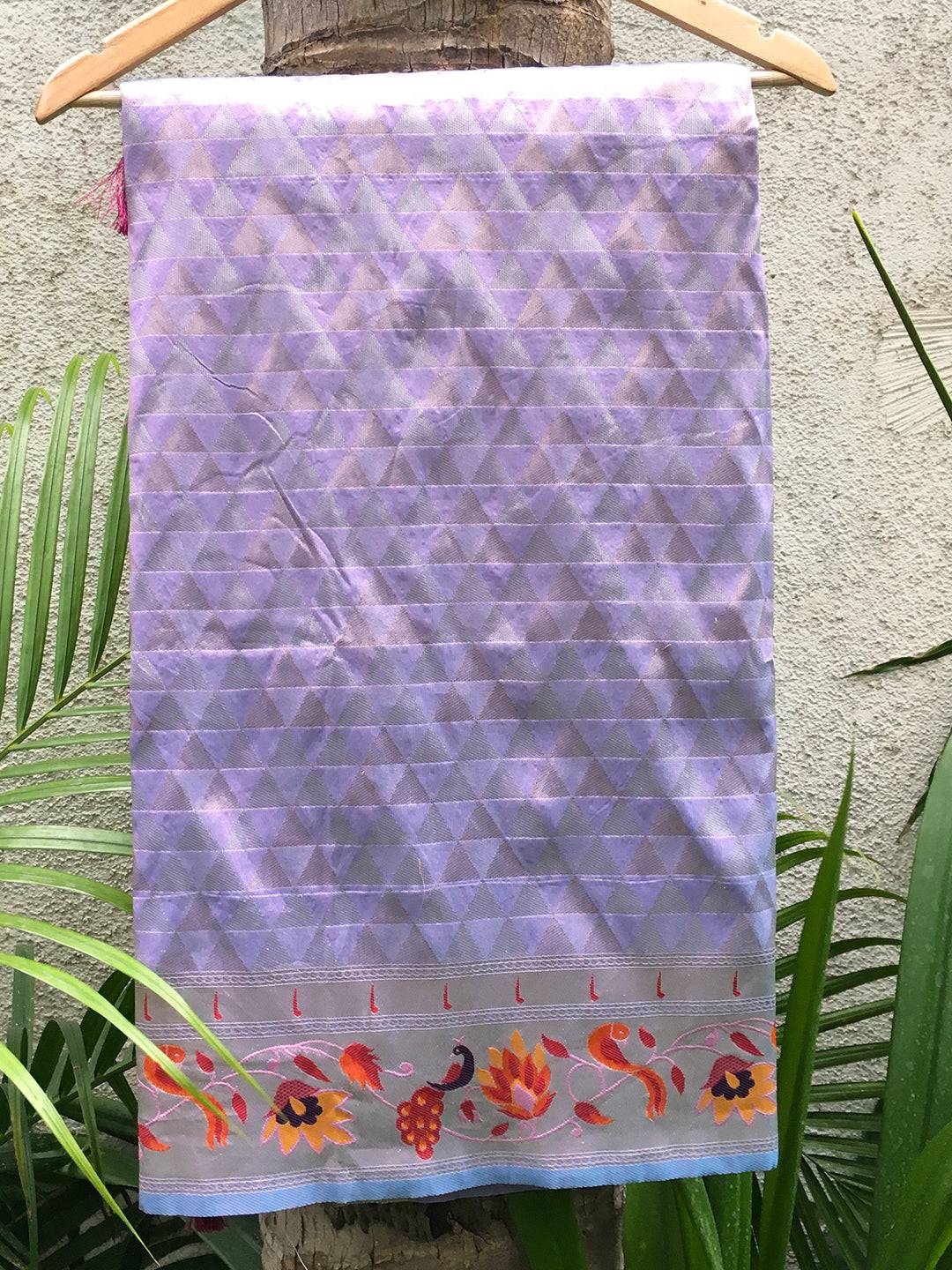 Lavender silk saree draped on hanger with floral border