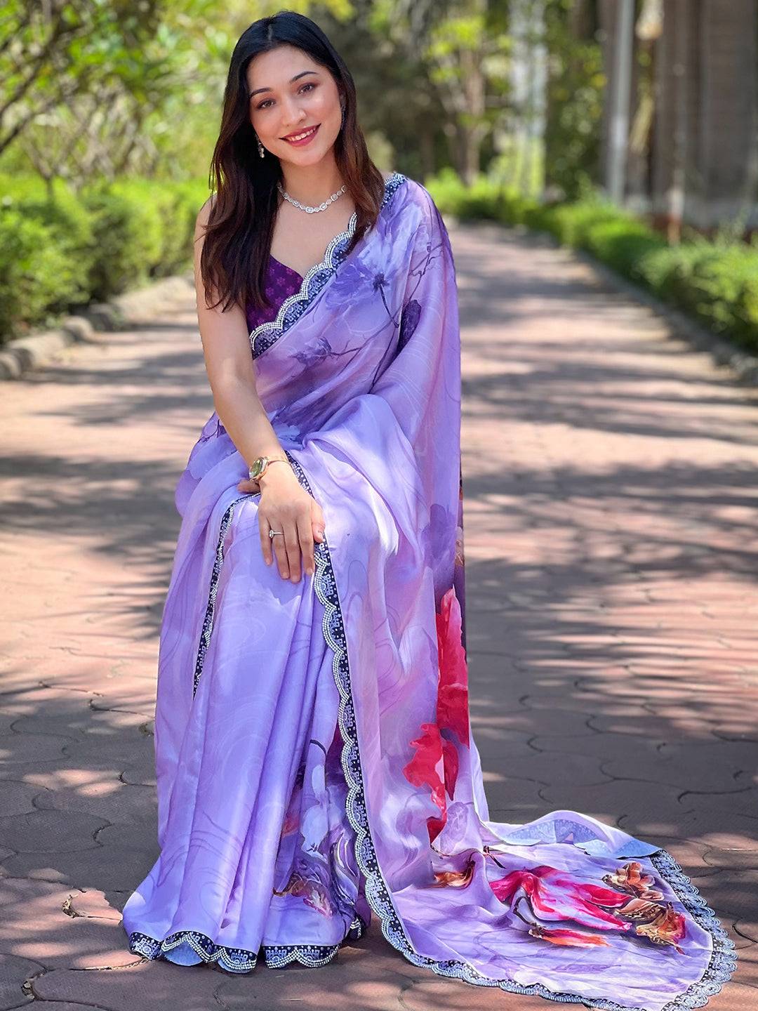 Woman seated in purple floral print saree with lace details