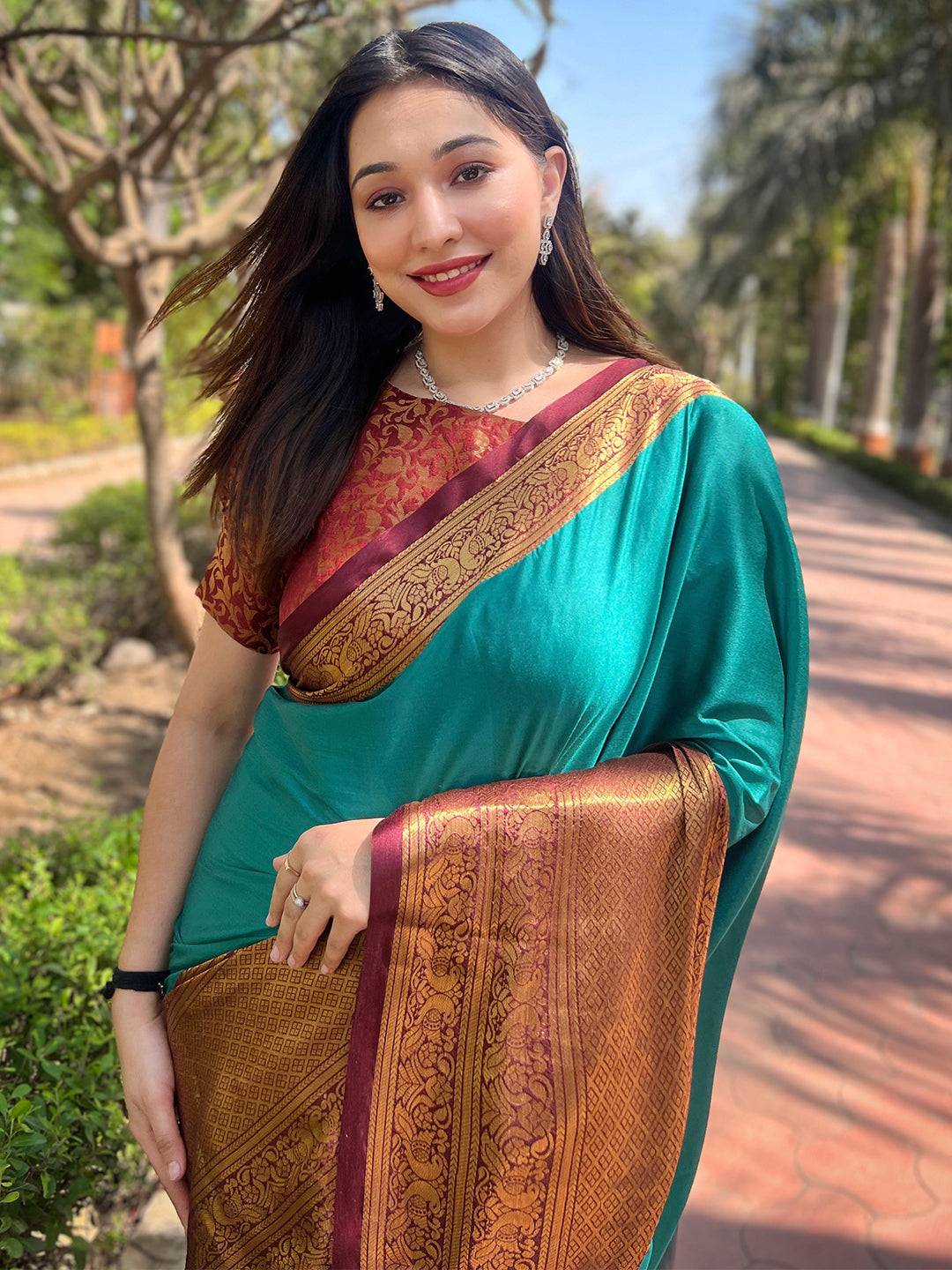 Woman in teal Kanjivaram saree with intricate weaving