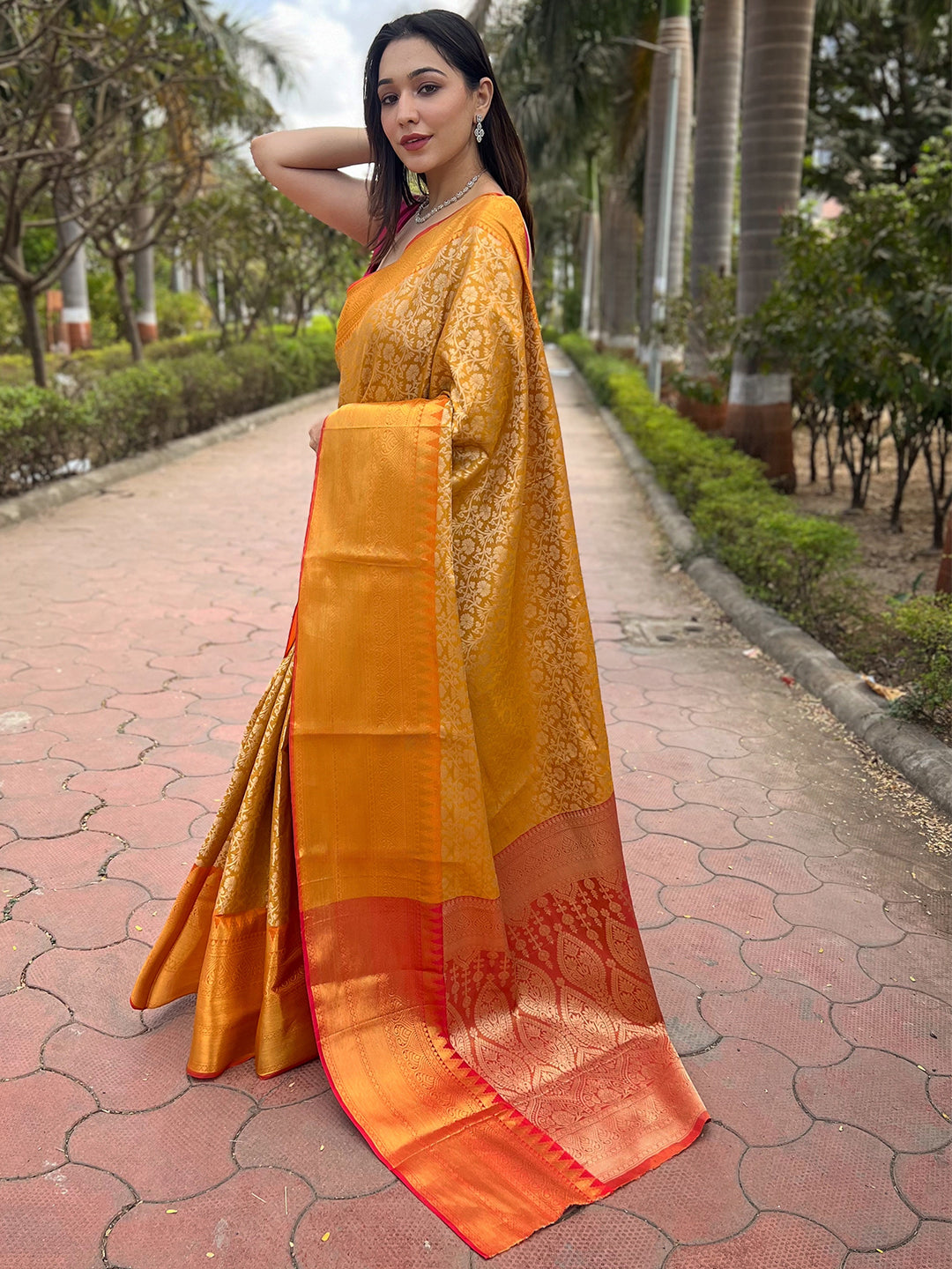 Yellow gold tissue saree with jacquard woven work, outdoor setting