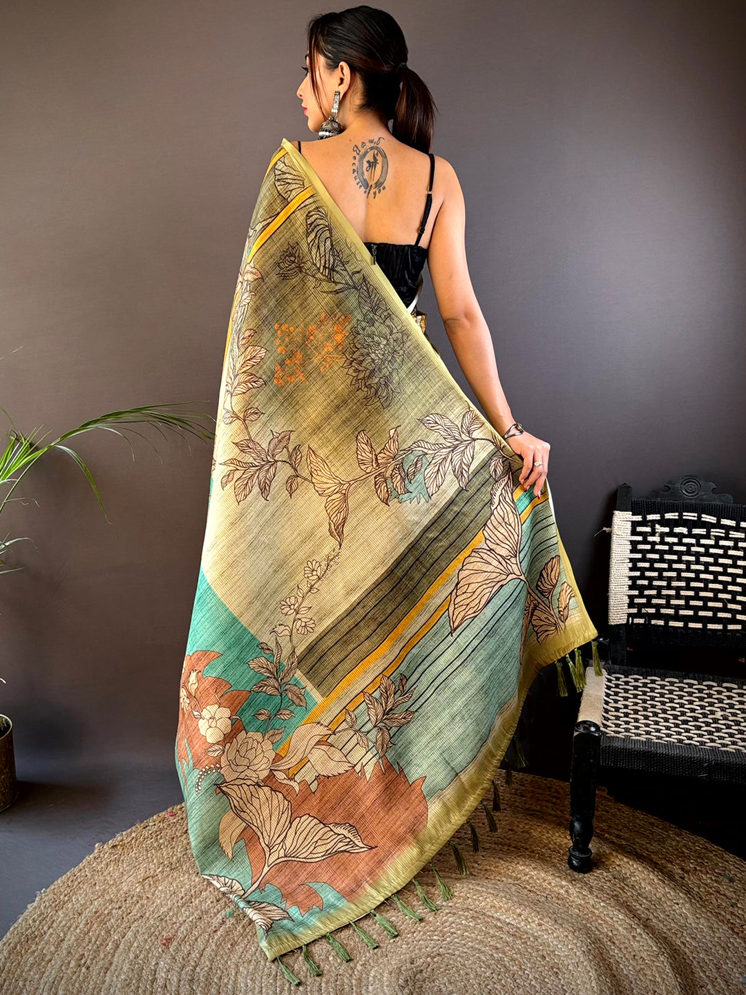 Back view of green floral zari tussar saree with intricate patterns.