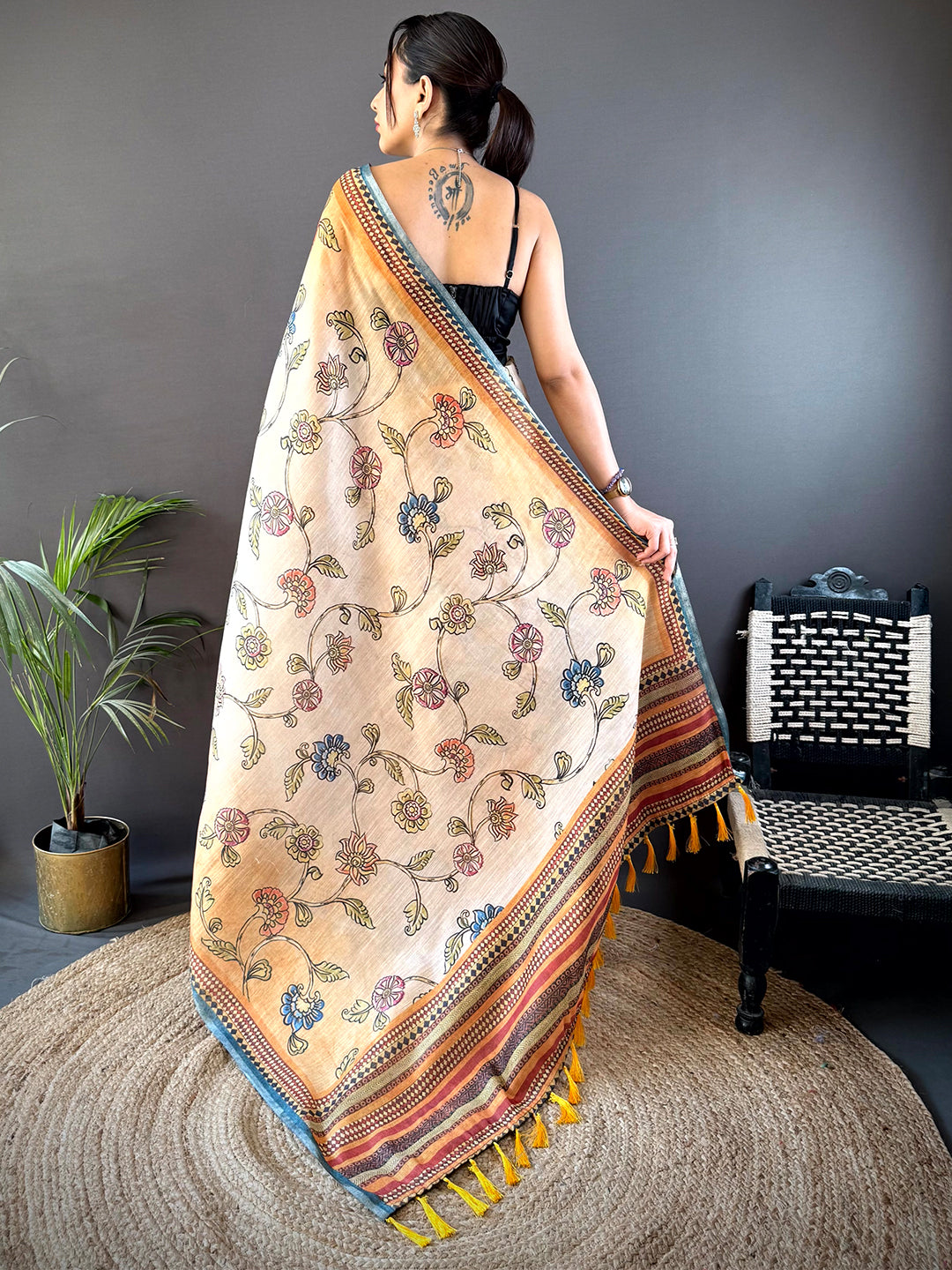 Back view of the Radiant Orange Zari Tussar Floral Saree showcasing intricate floral patterns and elegant tassel detailing for a timeless ethnic appeal.