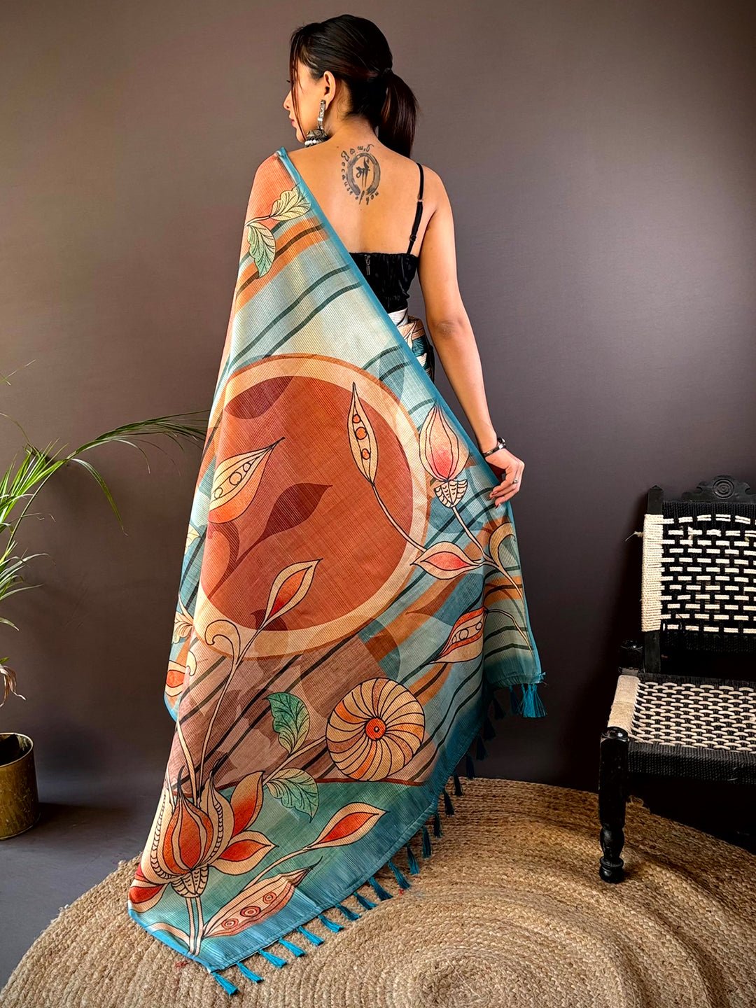 Back view of Teal Zari Tussar saree showcasing floral patterns.