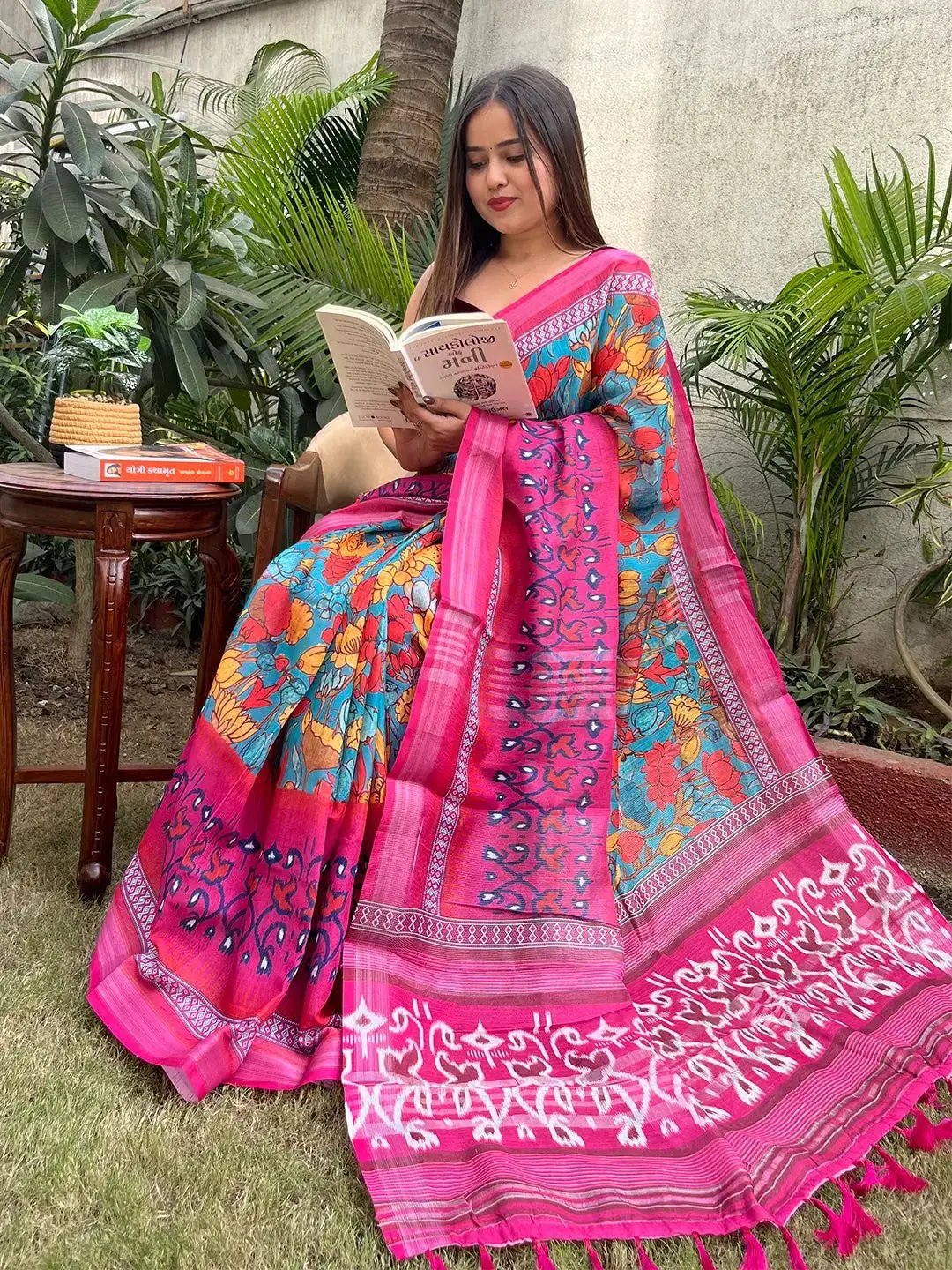 Woman reading in floral Ikkat printed party wear saree