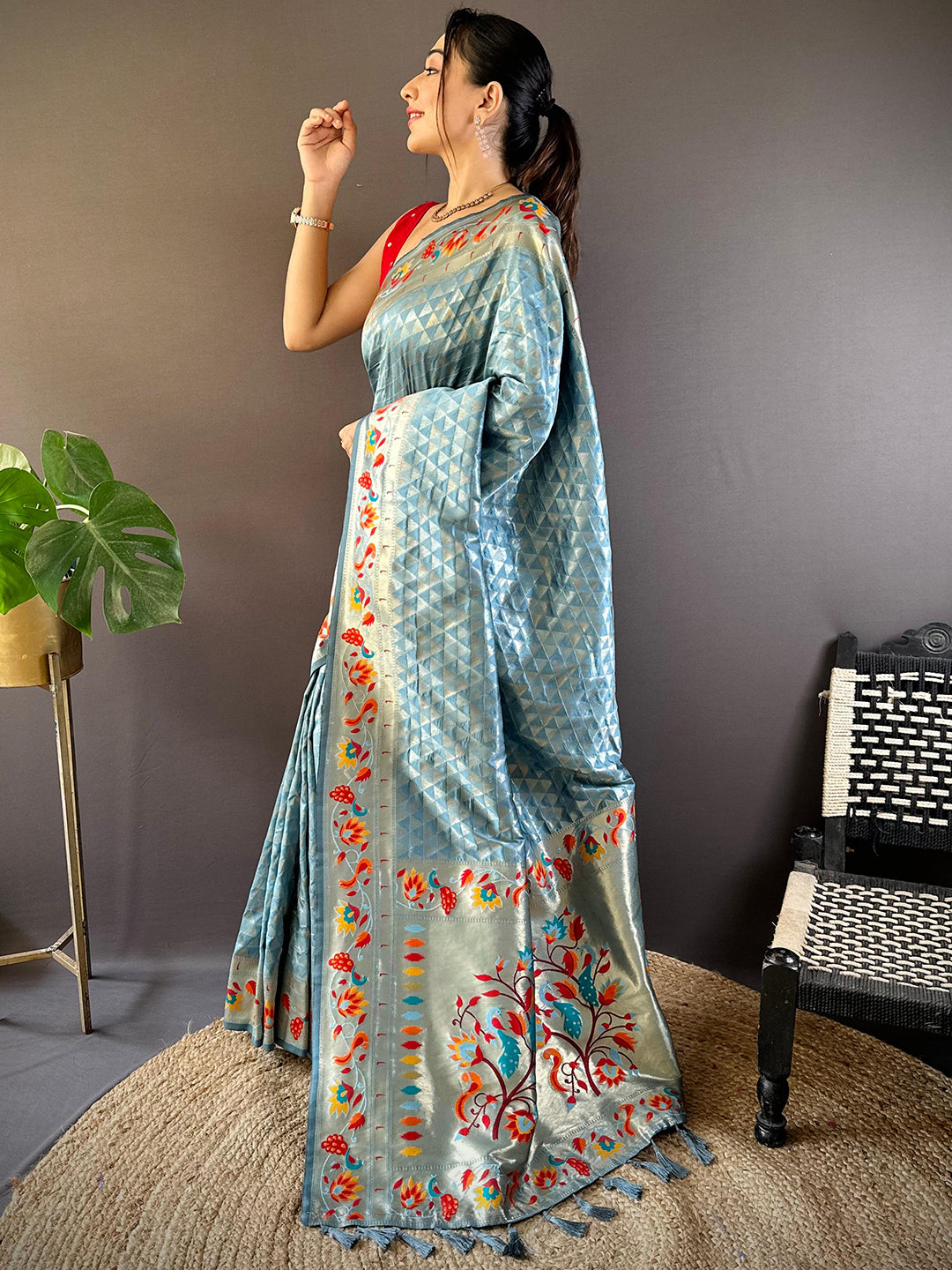 Side pose of model in light blue silk Paithani saree with zari.