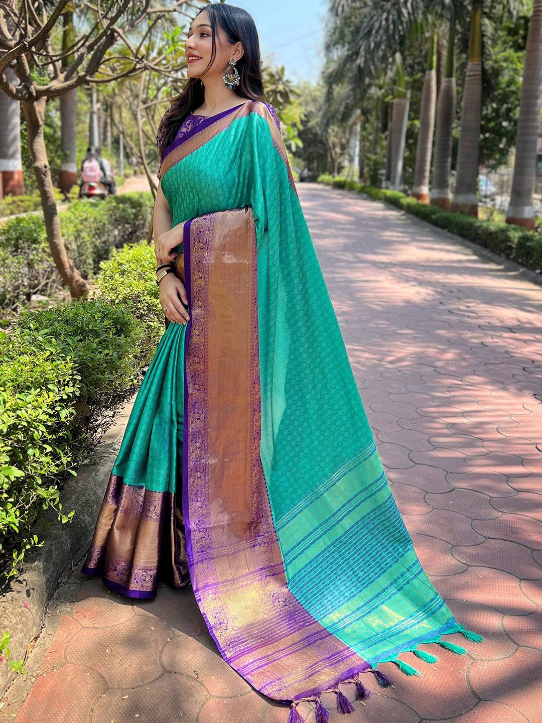 Model in turquoise Kanjivaram saree with intricate zari work