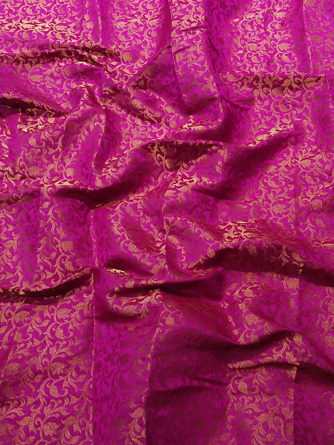 Close-up of brocade zari blouse fabric in vibrant pink