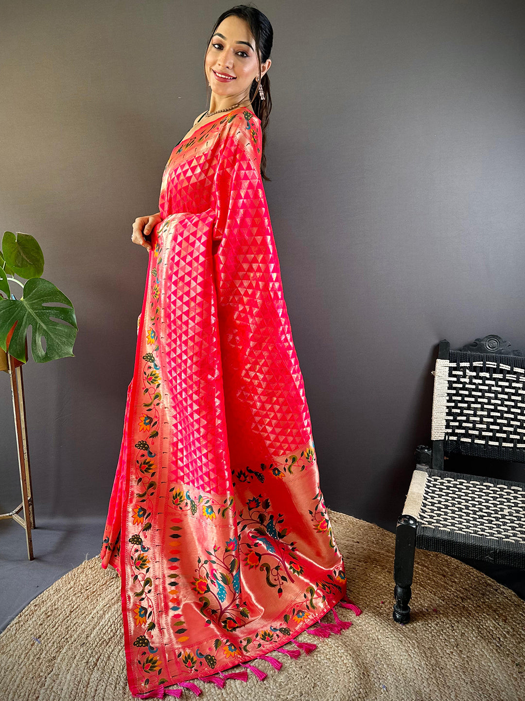 Side pose of woman in pink Paithani saree with woven zari work