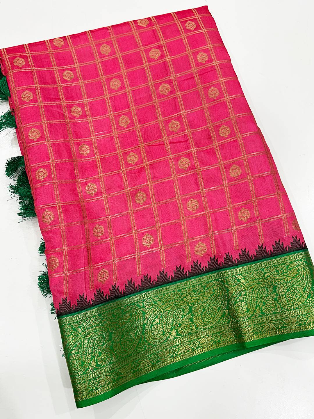 Folded blush pink Banarasi saree showcasing green border design