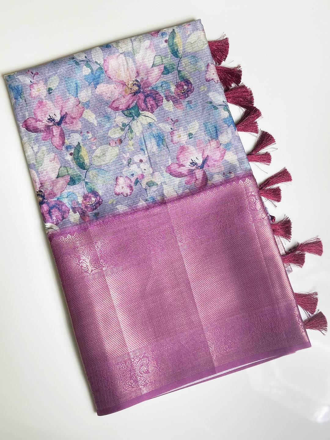 Folded lavender saree showcasing floral print and tassels