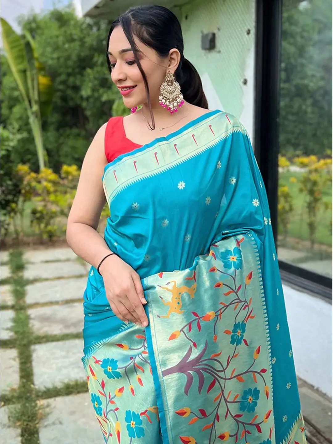 Close-up of turquoise Paithani saree with intricate floral pattern