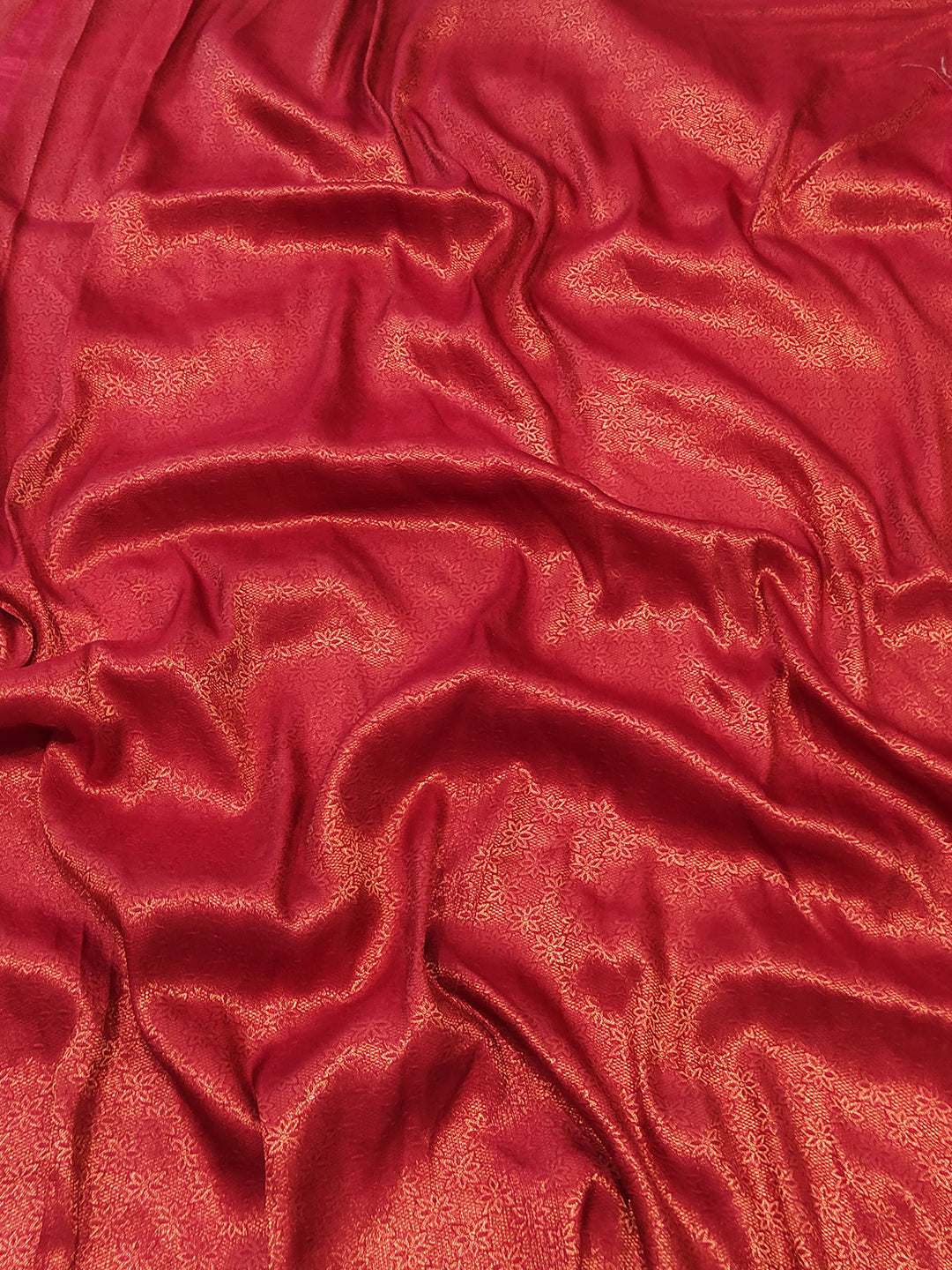 Close-up of red silk fabric with subtle patterns