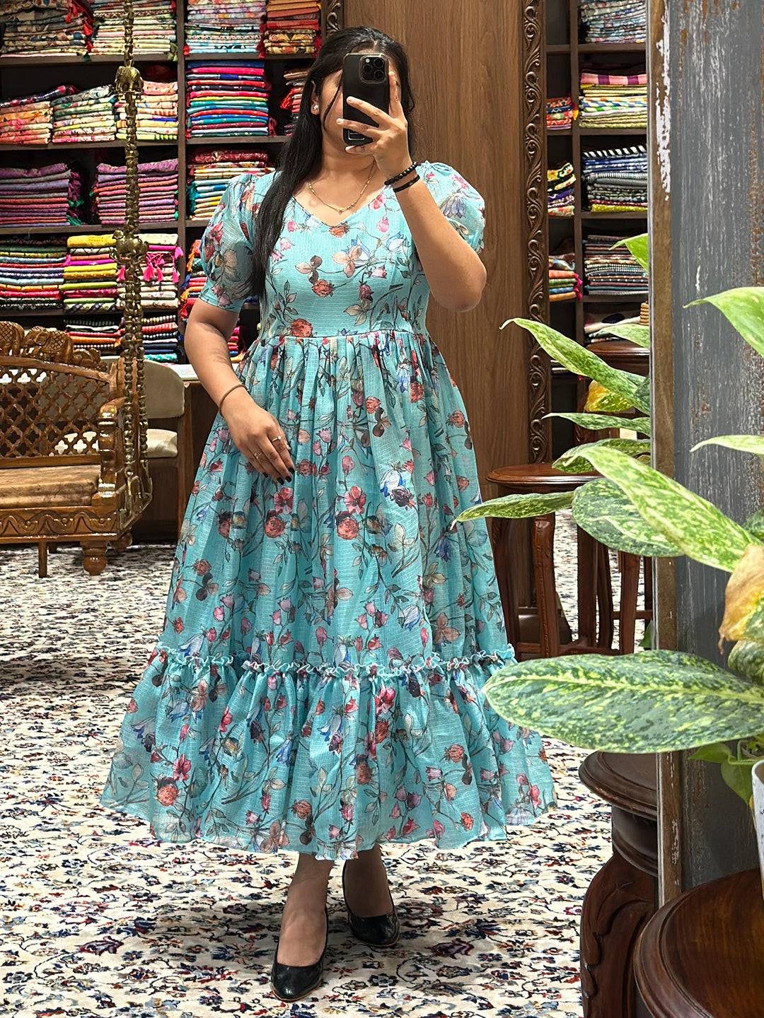 Elegant powder blue dress featuring floral print and flared silhouette.