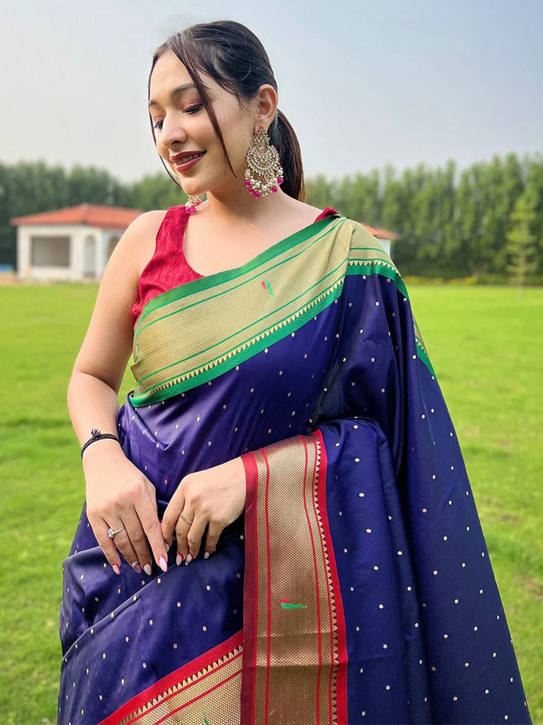 Woman wearing navy blue Paithani saree with Ganga Jamuna border