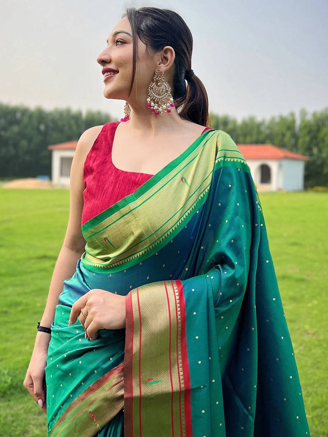 Woman wearing teal Paithani saree with Ganga Jamuna border.