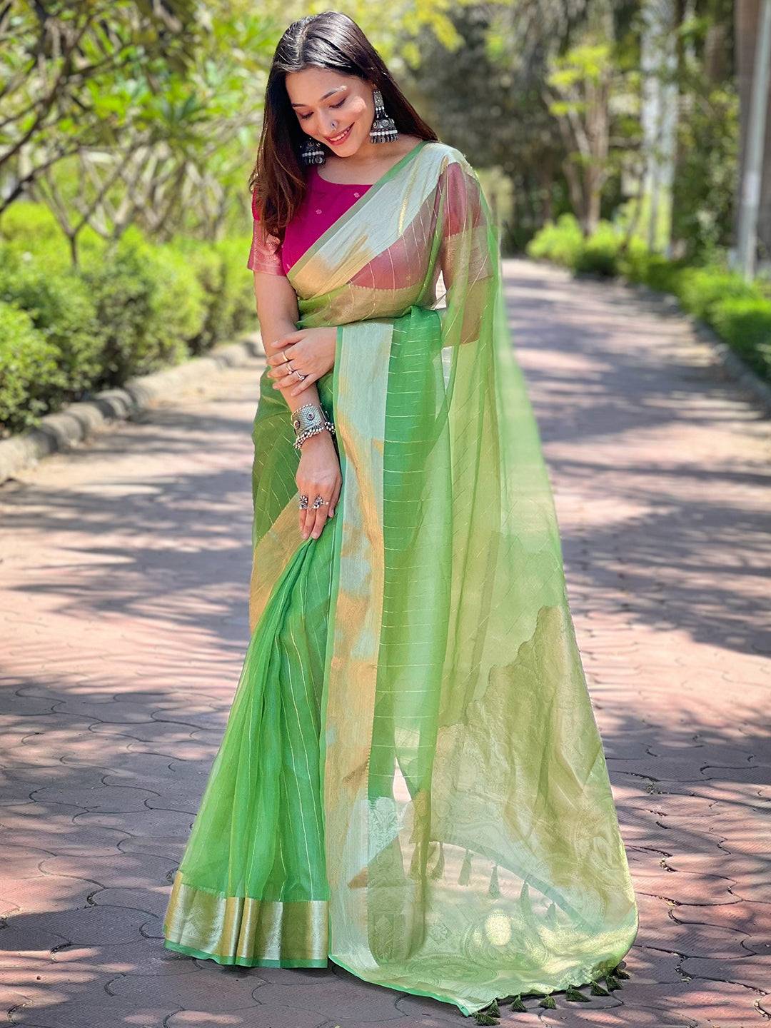 Elegant green organza saree with fine gold zari border.