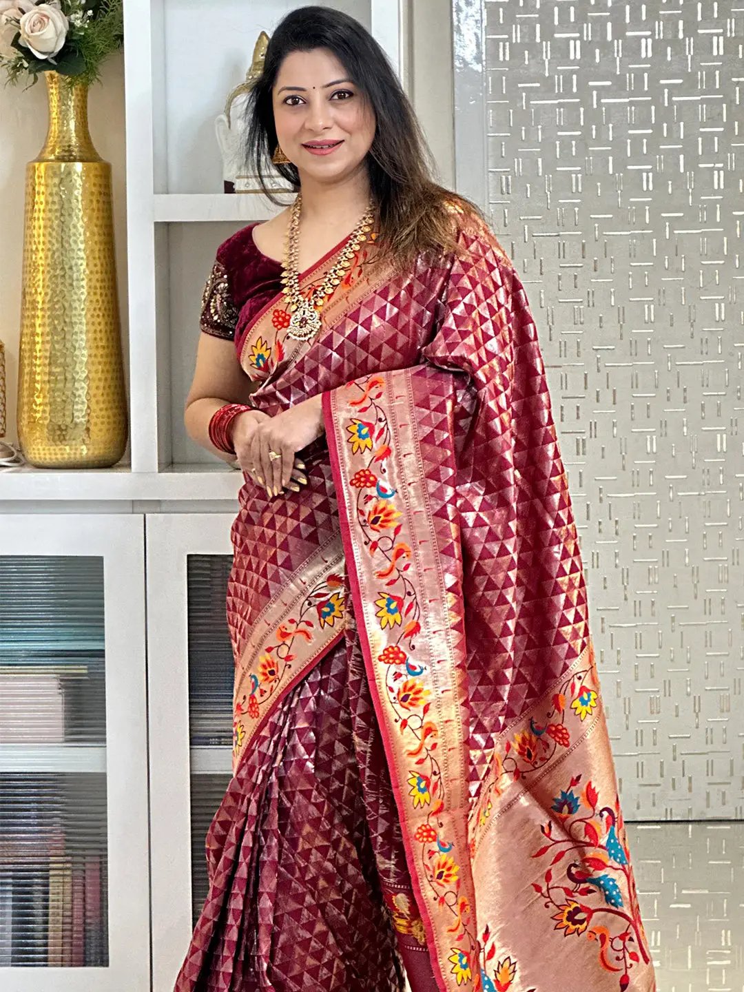 Model in wine silk blend Paithani saree with intricate zari design.