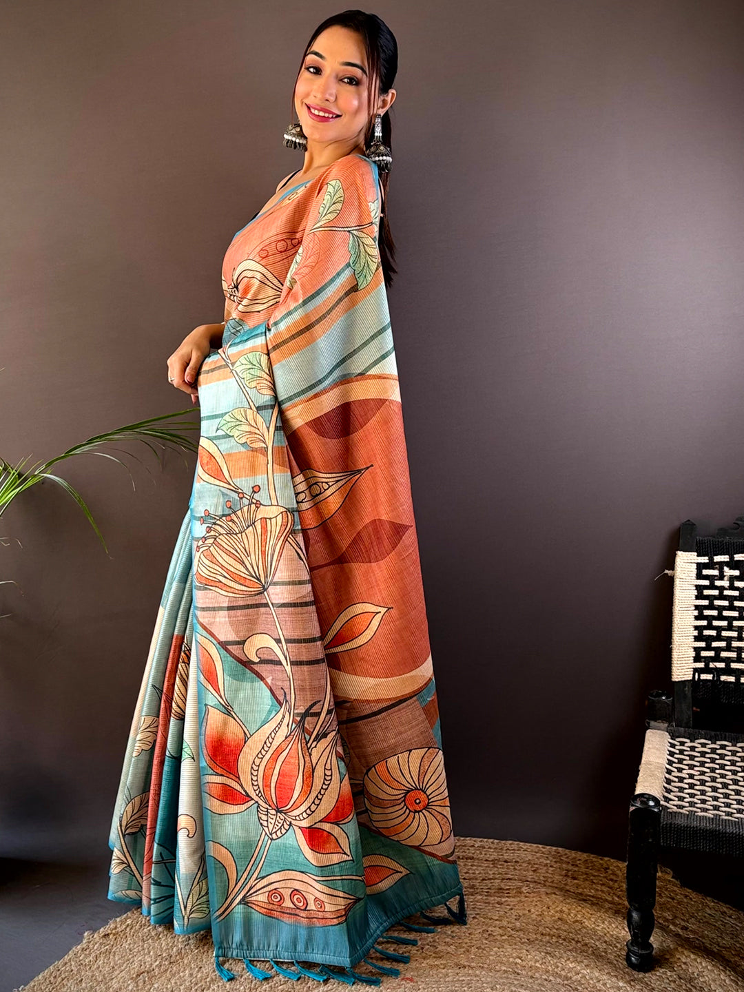 Side pose of model in Teal Zari Tussar saree with floral motifs.