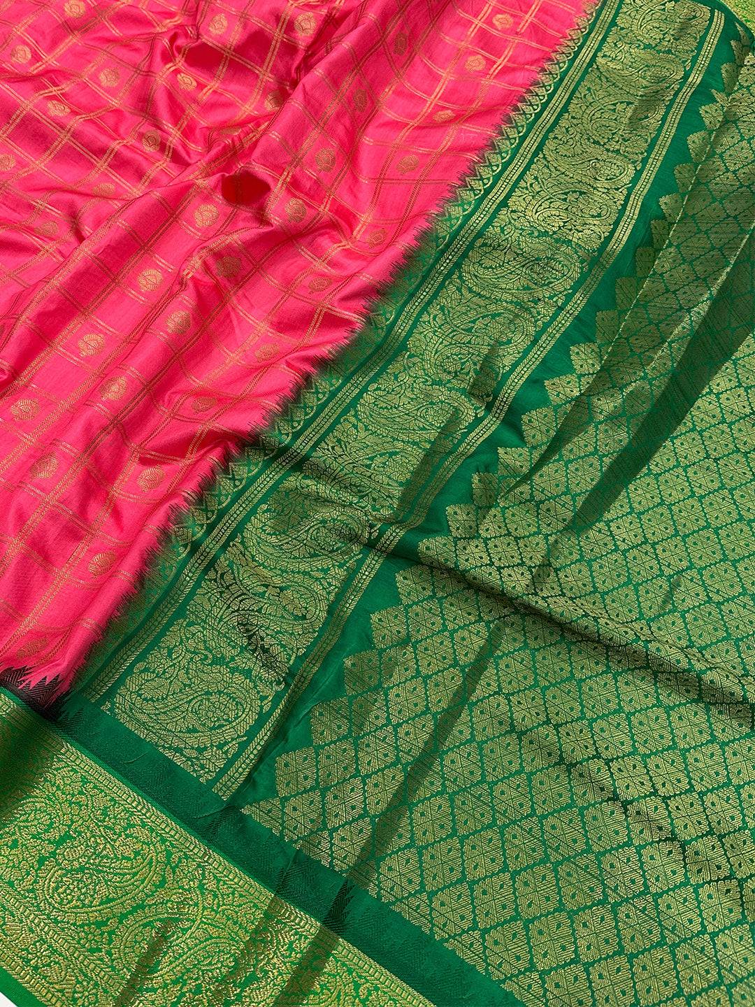 Close-up of blush pink Banarasi saree with detailed green border