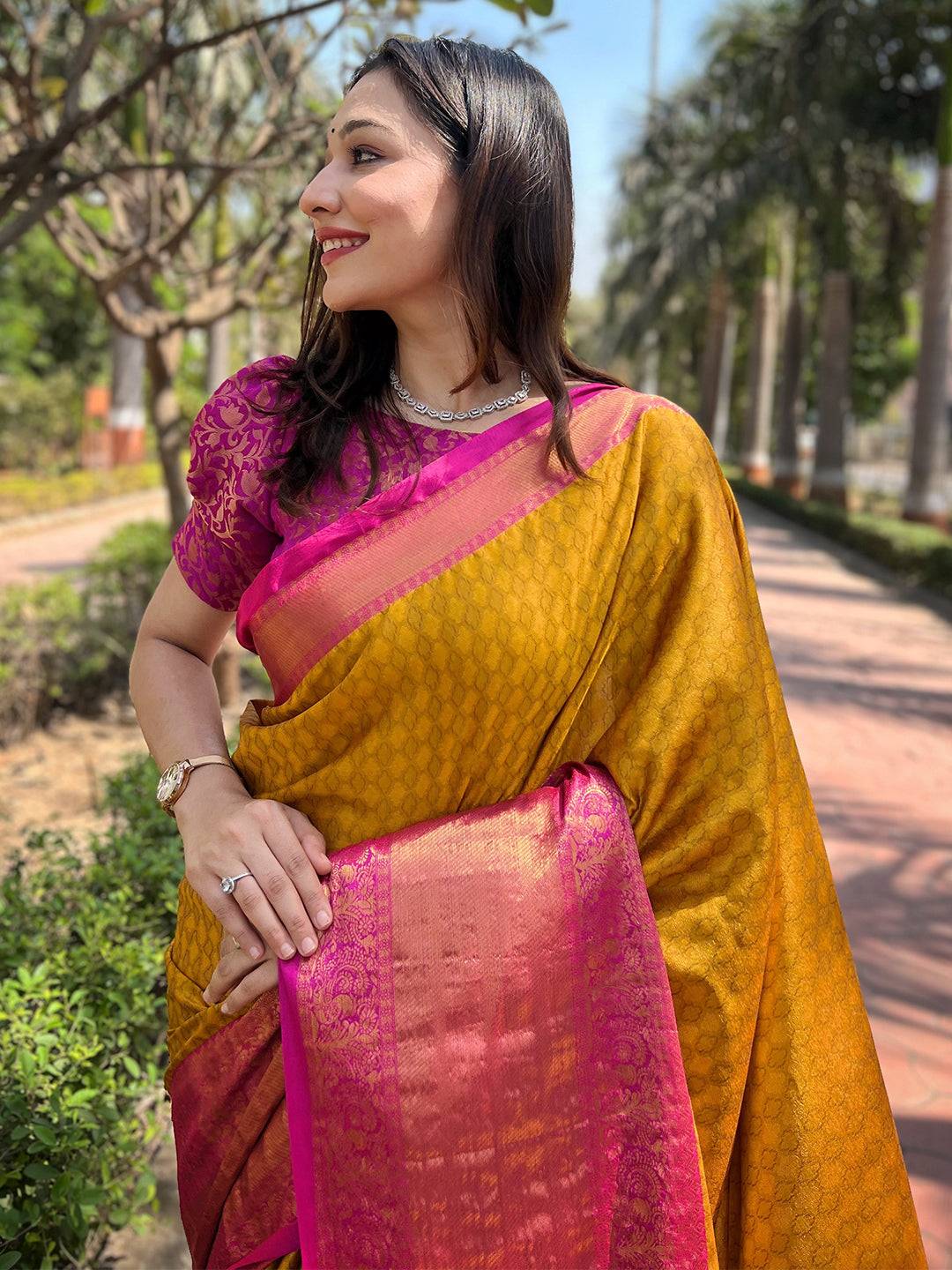 Mustard Kanjivaram silk saree with pink border, outdoor setting