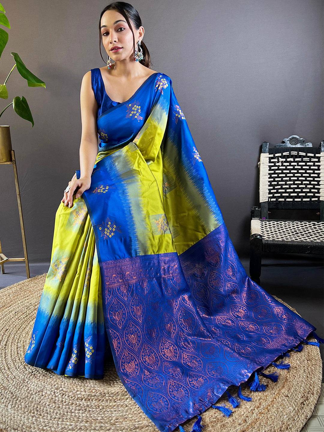 Model seated in blue and green Banarasi silk saree