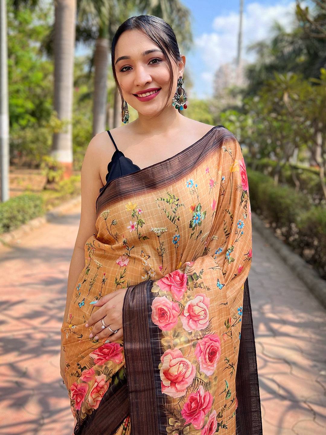 Model wearing orange silk saree with floral and zari details