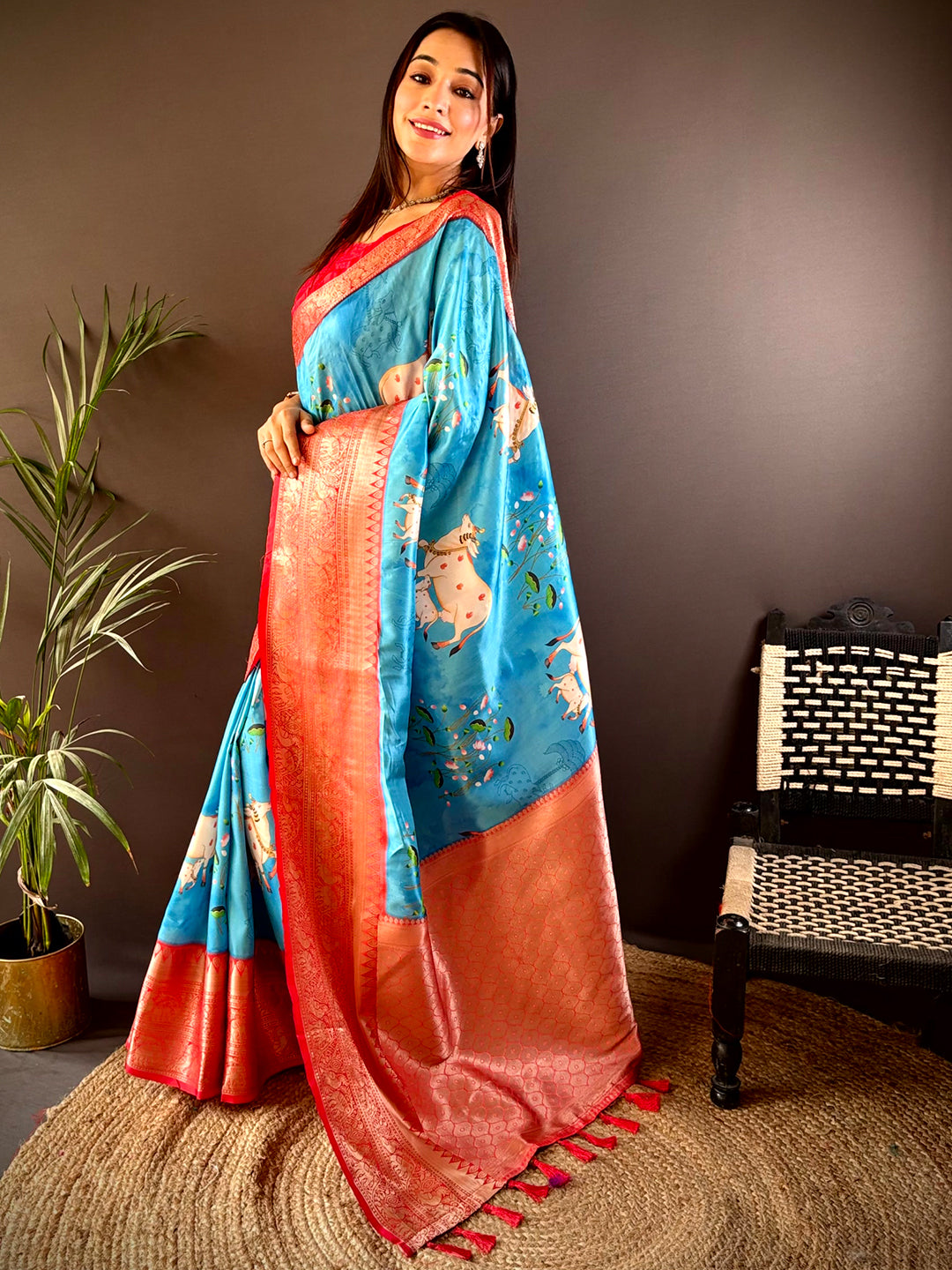 Model wearing blue silk saree with Pichwai Kalamkari print and red border