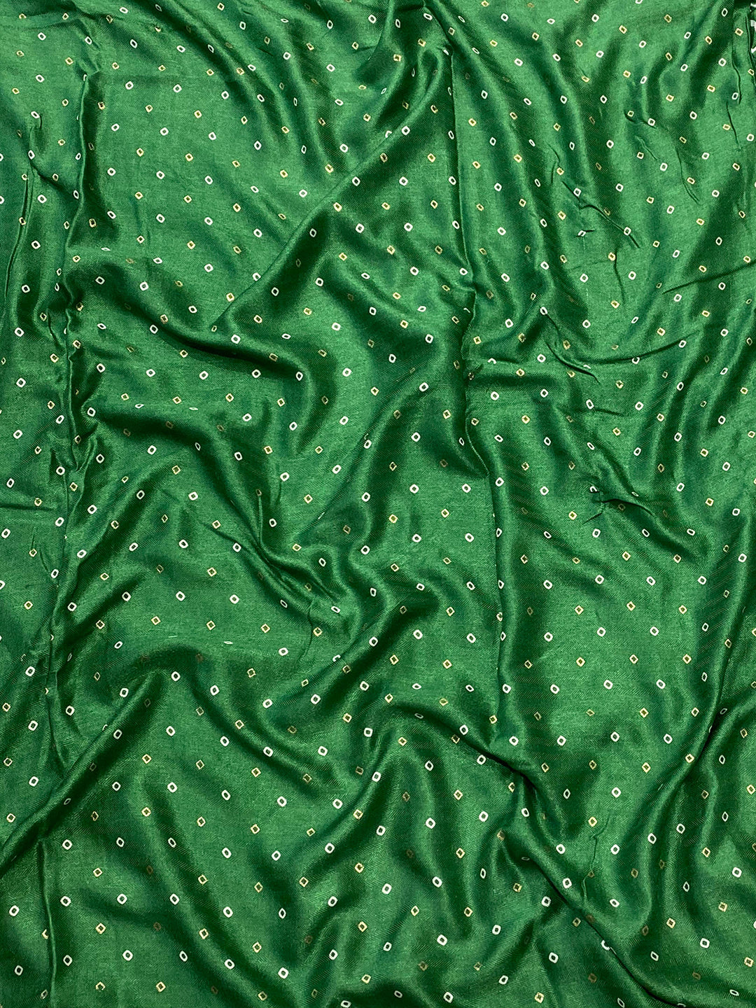 Close-up of green silk fabric with small foil print dots