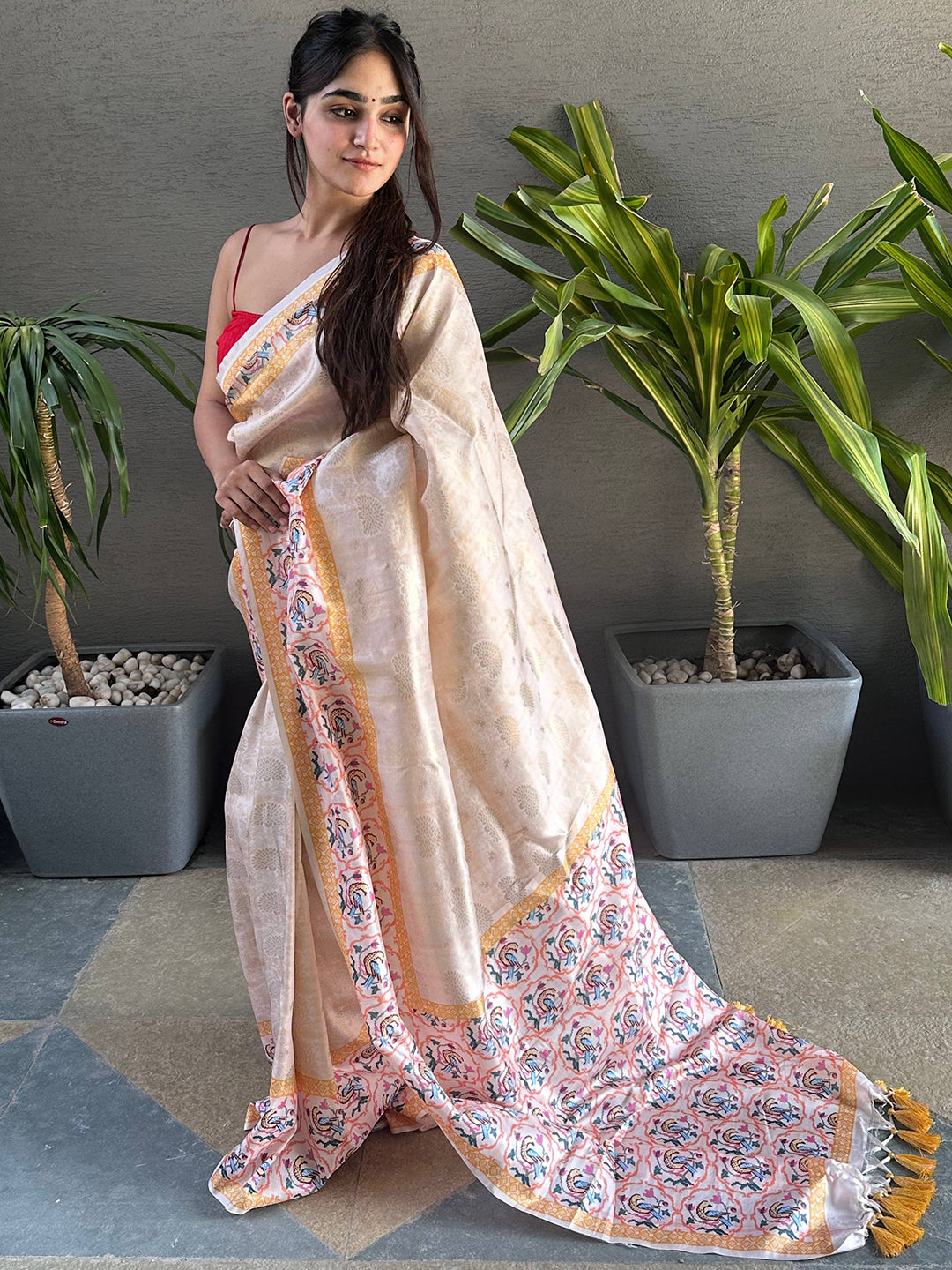 Model showcasing cream Kanjivaram saree with colorful Patola design