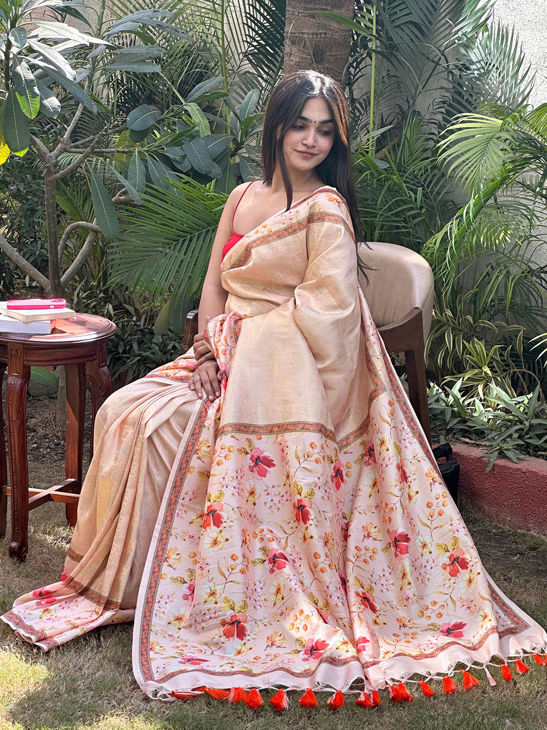 Peach Kanjivaram saree with floral design displayed outdoors