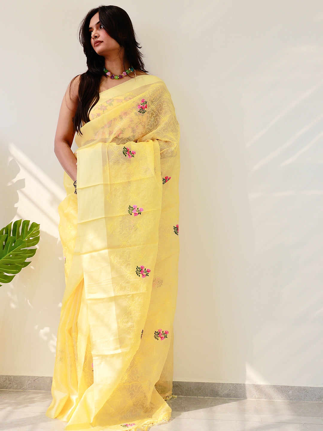 Elegant yellow saree with floral embroidery, draped on model.