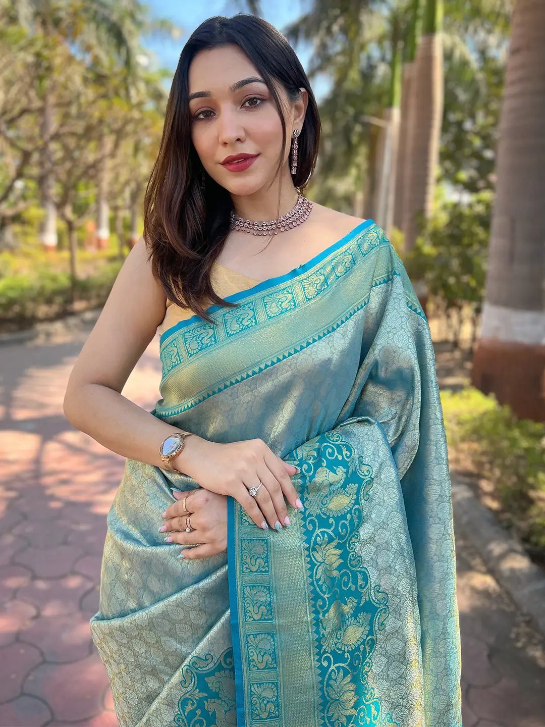 Woman showcasing intricate design of Kanjivaram silk saree