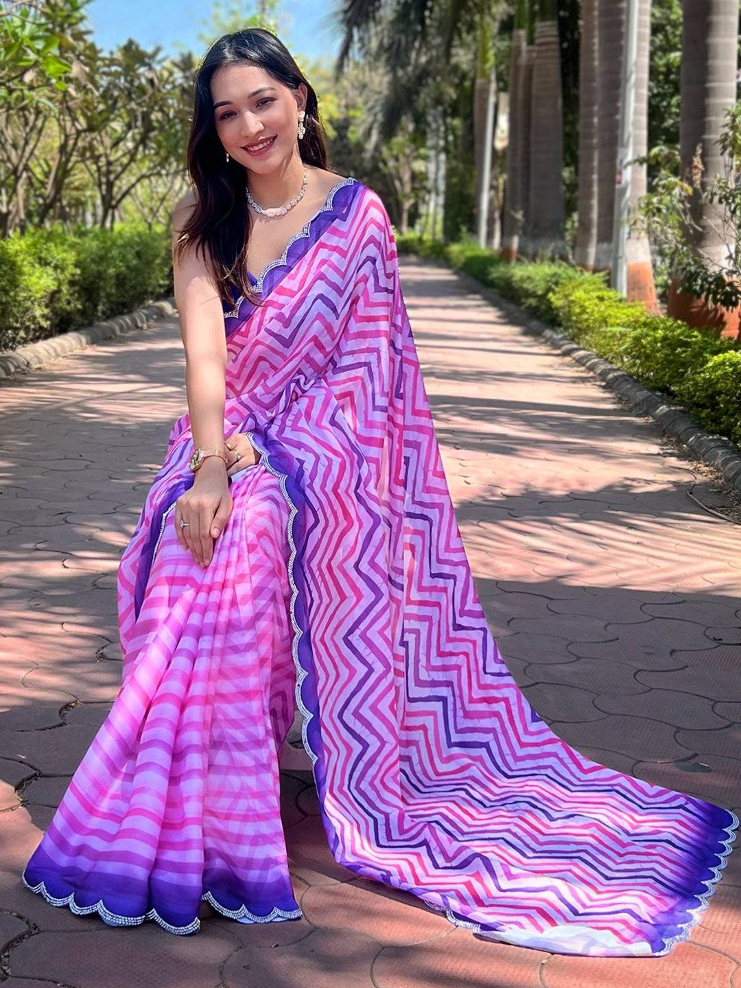 Seated pose in pink and purple leheriya saree