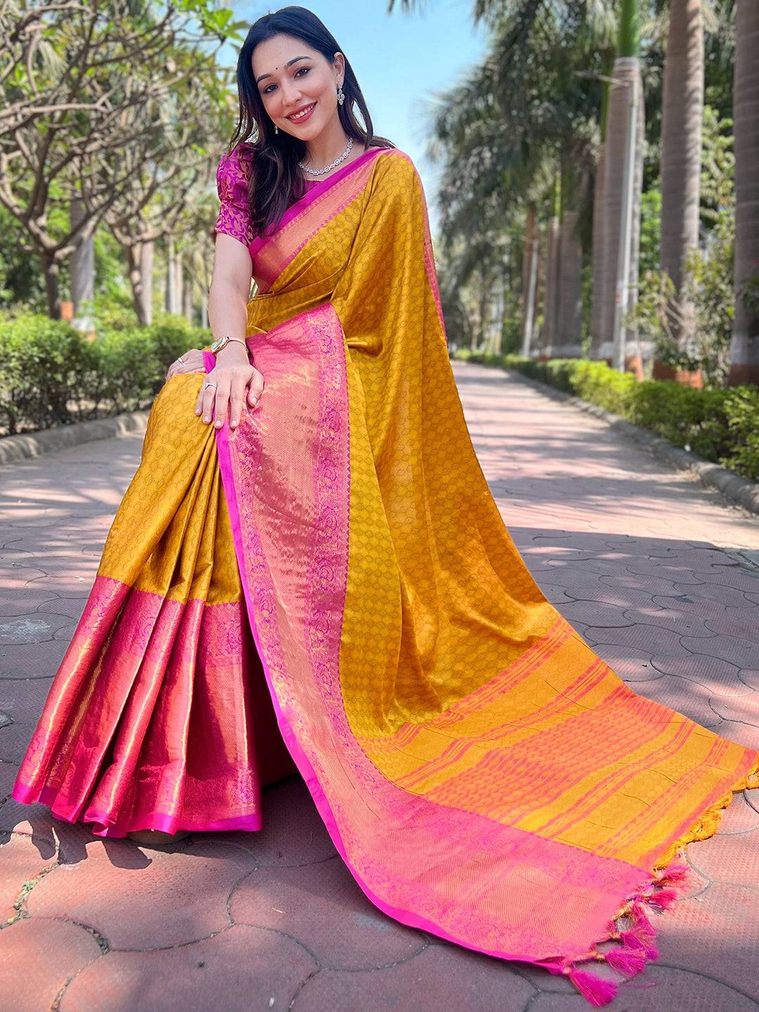 Mustard Kanjivaram saree draped elegantly with pink details