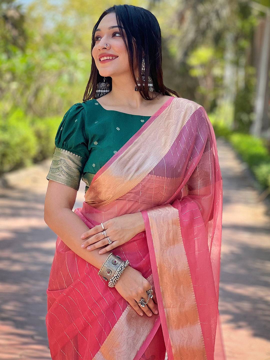 Dark pink organza saree with gold zari border, worn by a model.