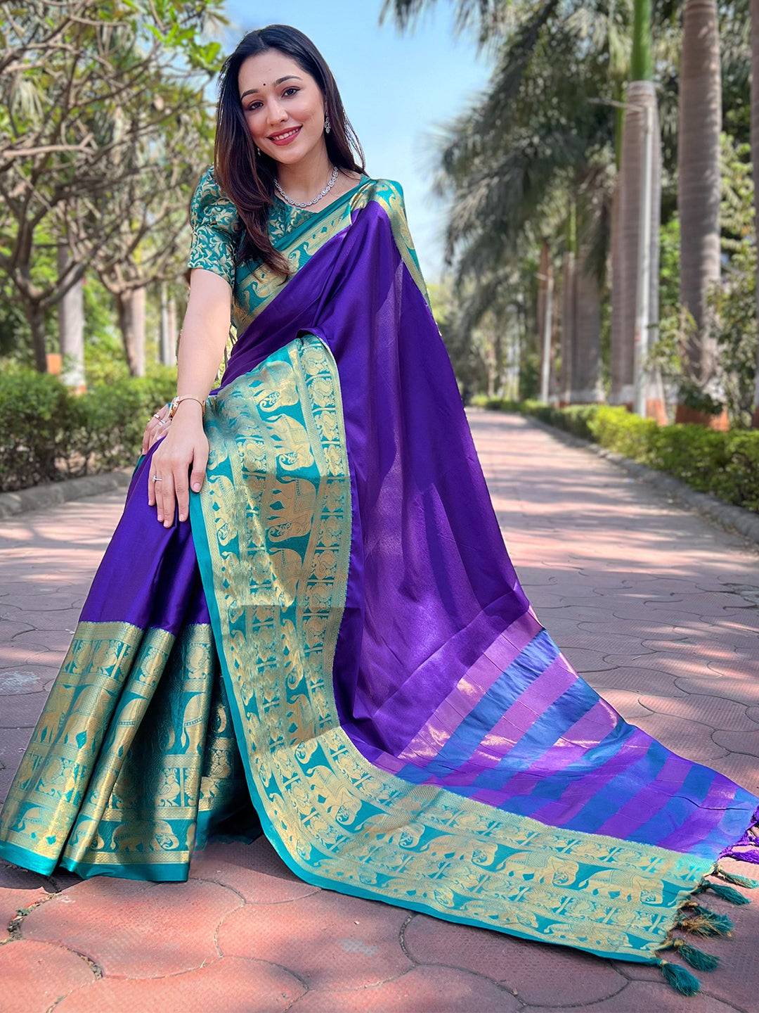 Woman sitting in indigo Kanjivaram saree with gold patterns