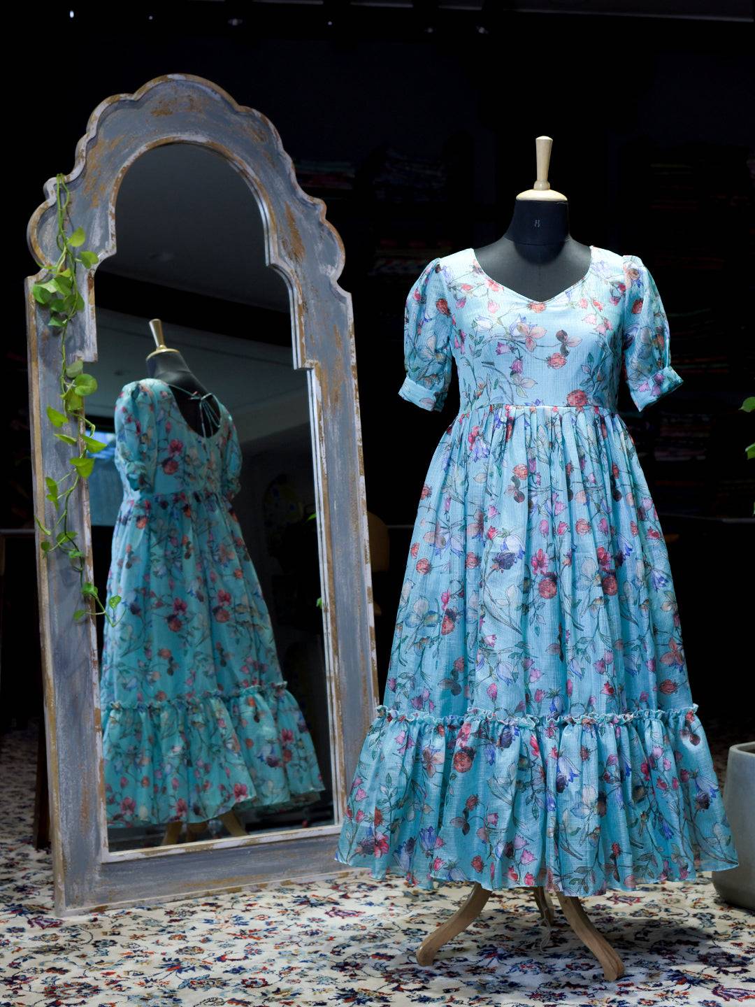 Mannequin displaying powder blue floral print dress with V-neckline.