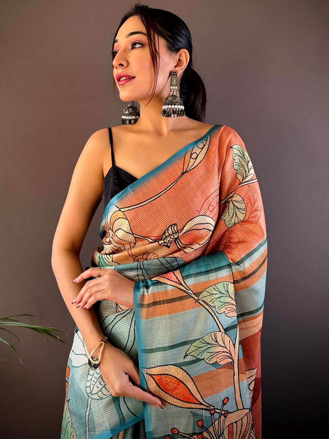 Teal Zari Tussar printed saree with floral design, model posing.