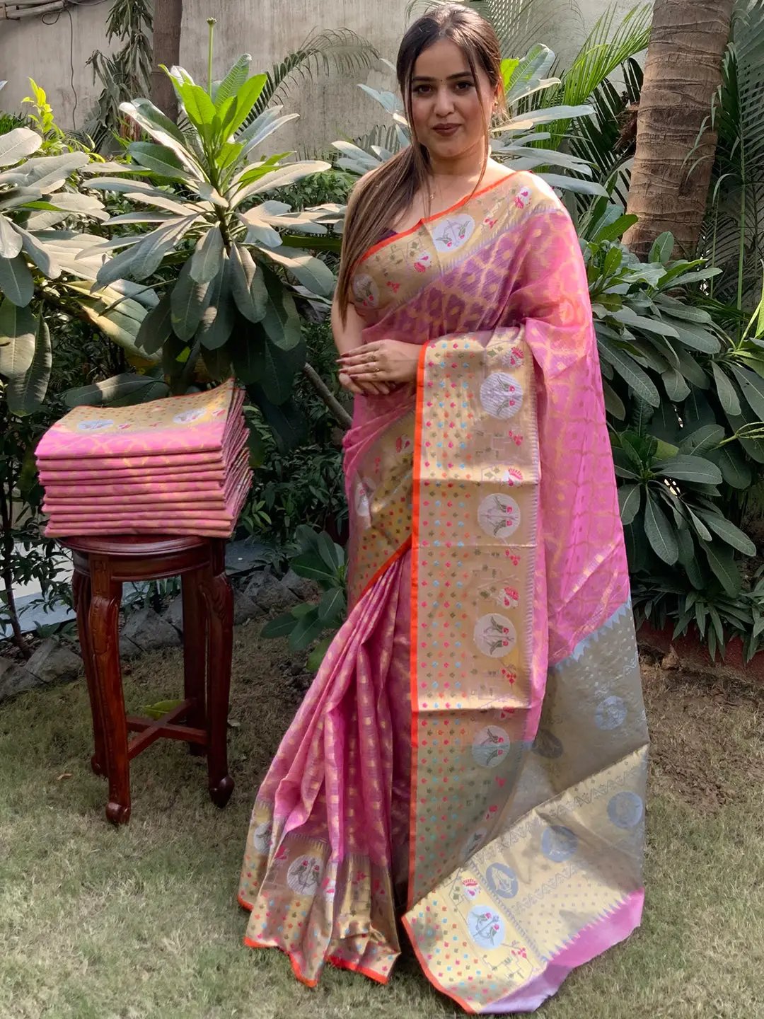 Pink Kota Doria silk saree displayed by model in garden