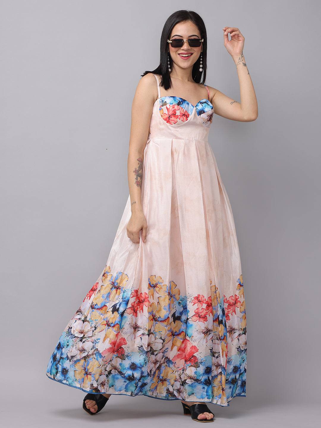 Woman in cream floral dress posing with sunglasses