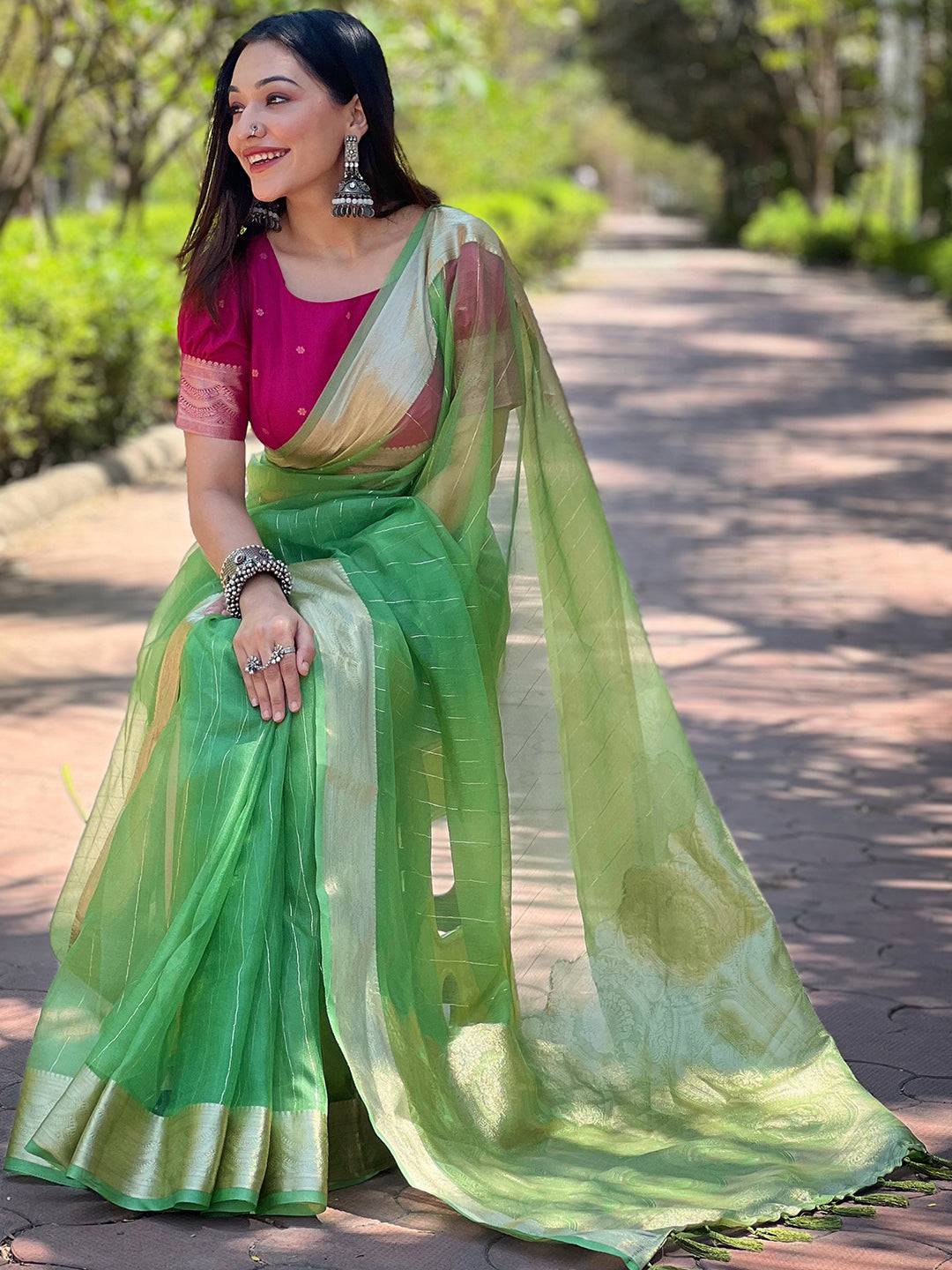 Green organza saree with gold border, paired with pink blouse.