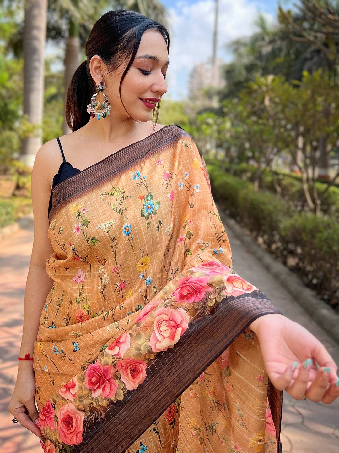 Close-up of floral print on orange silk saree with zari